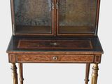 a small wooden cabinet with a glass door on top of it