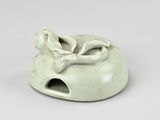a small white ceramic object with a bird on it