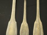 three forks and a spoon are sitting on a table