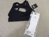 Le haut d'un soutien-gorge de sport noir se trouve à côté d'un colis emballé
