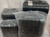 quatre bagages emballés dans du plastique, posés sur une table