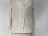 beige sweater on a mannequin stand against a white backdrop