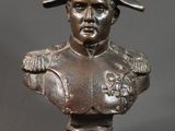 buste en bronze d'un homme coiffé d'un chapeau, posé sur une table noire