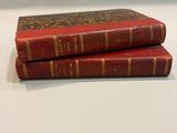 two red books sitting on top of each other on a table