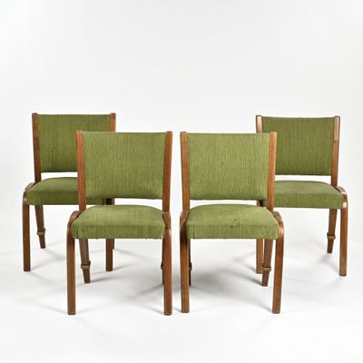 quatre chaises rembourrées vertes avec des pieds en bois et une assise rembourrée verte
