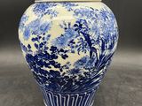 a close up of a blue and white vase on a table