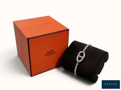 une boîte orange contenant un bracelet à maillons et un sac noir