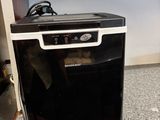 a small black dishwasher sitting on top of a counter