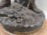 bronze statue of a man with boots and a bird on a pedestal