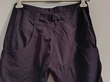 purple pants hanging on a hanger on a wall in a room