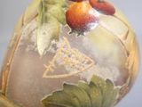 un gros plan d'un vase orné de fruits et de feuilles