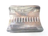 a metal comb that is sitting on top of a table