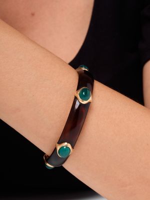 un gros plan sur le bras d'une femme portant un bracelet marron et vert