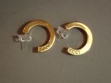 une paire de boucles d'oreilles créoles plaquées or, ornées du mot « frecc »