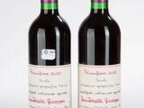 deux bouteilles de vin rouge posées l'une à côté de l'autre sur une surface blanche