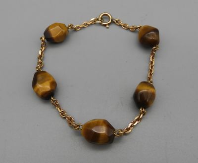 un bracelet composé de perles « œil-de-tigre » et d'une chaîne en or