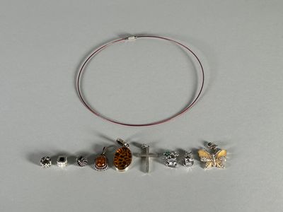 a necklace with a cross, a cow, and other charms on it