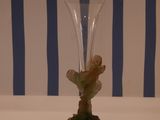 a glass vase with a flower in it sitting on a table