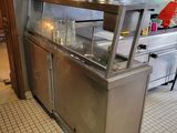 a kitchen with a stove, sink, oven, and cabinets