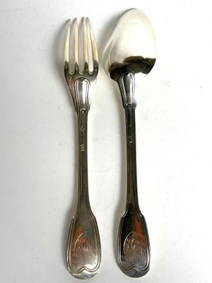 two spoons and a fork on a white table