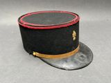 un chapeau noir orné d'un ruban rouge sur le dessus