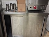 une petite cuisine équipée d'appareils électroménagers en inox et d'un sac en papier posé sur le plan de travail