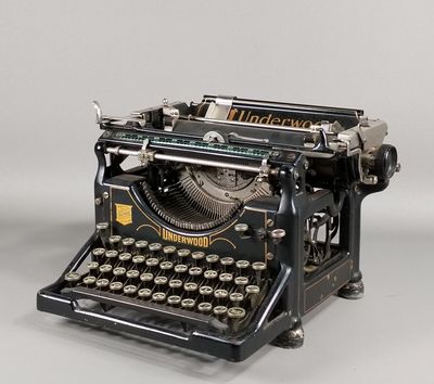 une vieille machine à écrire posée sur une surface blanche