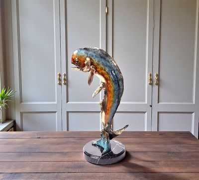une statue représentant un poisson, posée sur une table en bois