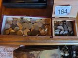 a lot of coins in a wooden box on a table