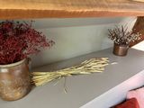 two vases with flowers on a shelf in a room
