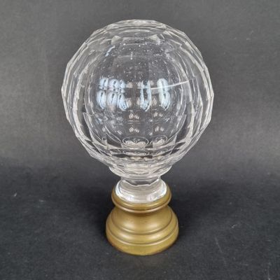 un gros plan d'une boule en verre transparent posée sur un socle doré
