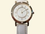 a close up of a wrist watch on a white strap
