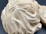 pair of carved stone sculptures of a woman ' s head and a man ' s head