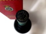 a bottle of wine sitting next to a red box