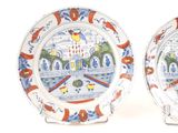 two plates with designs on them sitting on a white surface