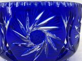 a blue glass bowl sitting on a white surface