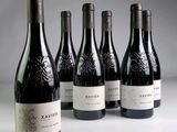 six bouteilles de vin sont alignées sur une table