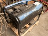 a small air compressor sitting on a pallet in a garage