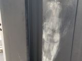 a silver refrigerator with a black door and a black handle