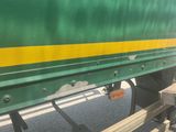a green and yellow train car on the street