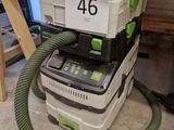 un dépoussiéreur vert et blanc et un aspirateur noir et blanc