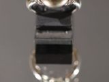 gros plan d'une bague en perles et diamants sur une surface noire