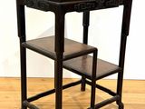 a small table with a stool on it on a hard wood floor