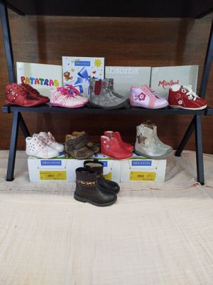 many pairs of children ' s shoes sitting on a shelf
