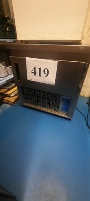 un ordinateur portable posé sur une table bleue, avec une étiquette de prix dessus