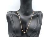 a black mannequin head with a gold chain on it