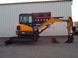 a picture of a small excavator parked in front of a building