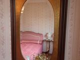 un miroir sur le mur au-dessus d'un lavabo dans une salle de bains