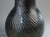 a blue and black vase sitting on a table