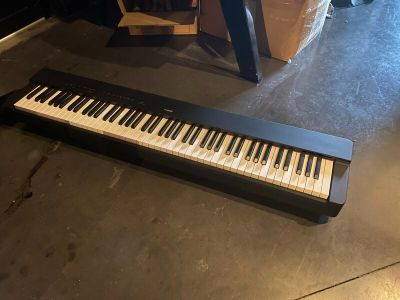 a piano that is sitting on the floor next to a chair